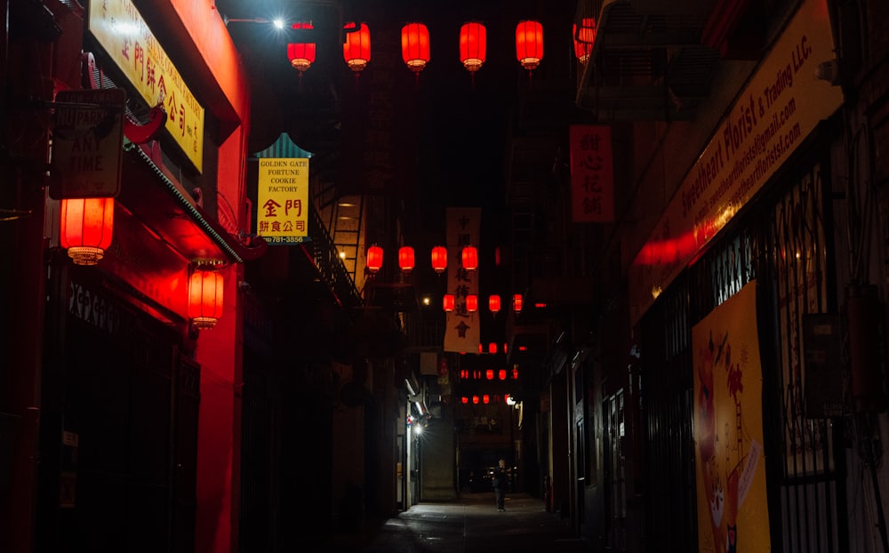 a dark alley with red lanterns hanging from the ceiling