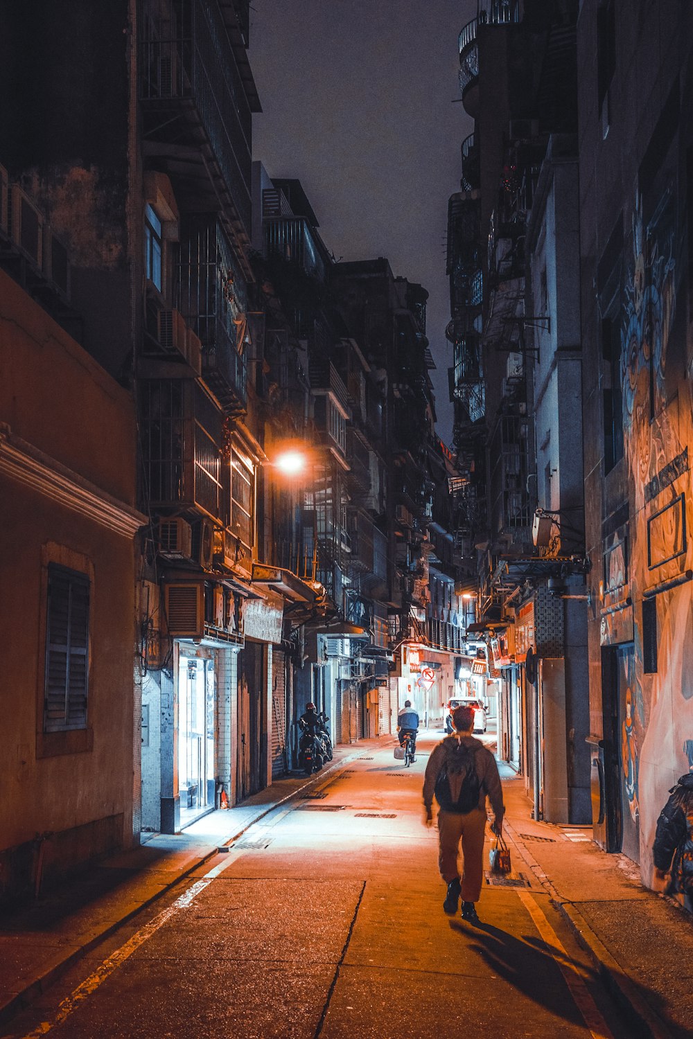 a man walking down a street at night