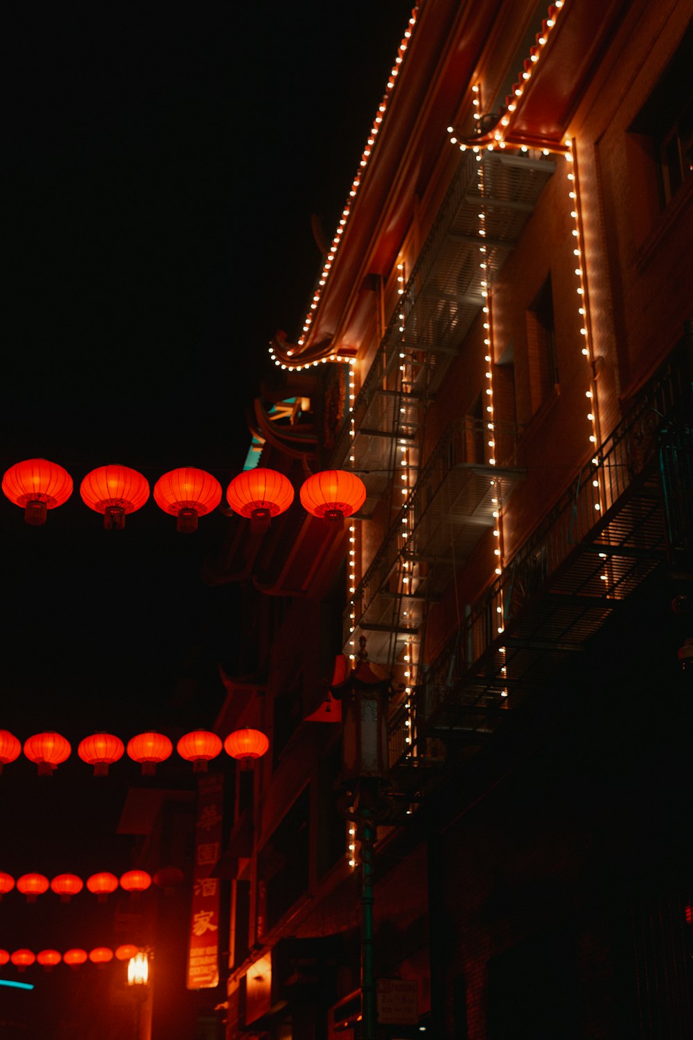 a building with red lanterns hanging from it's side