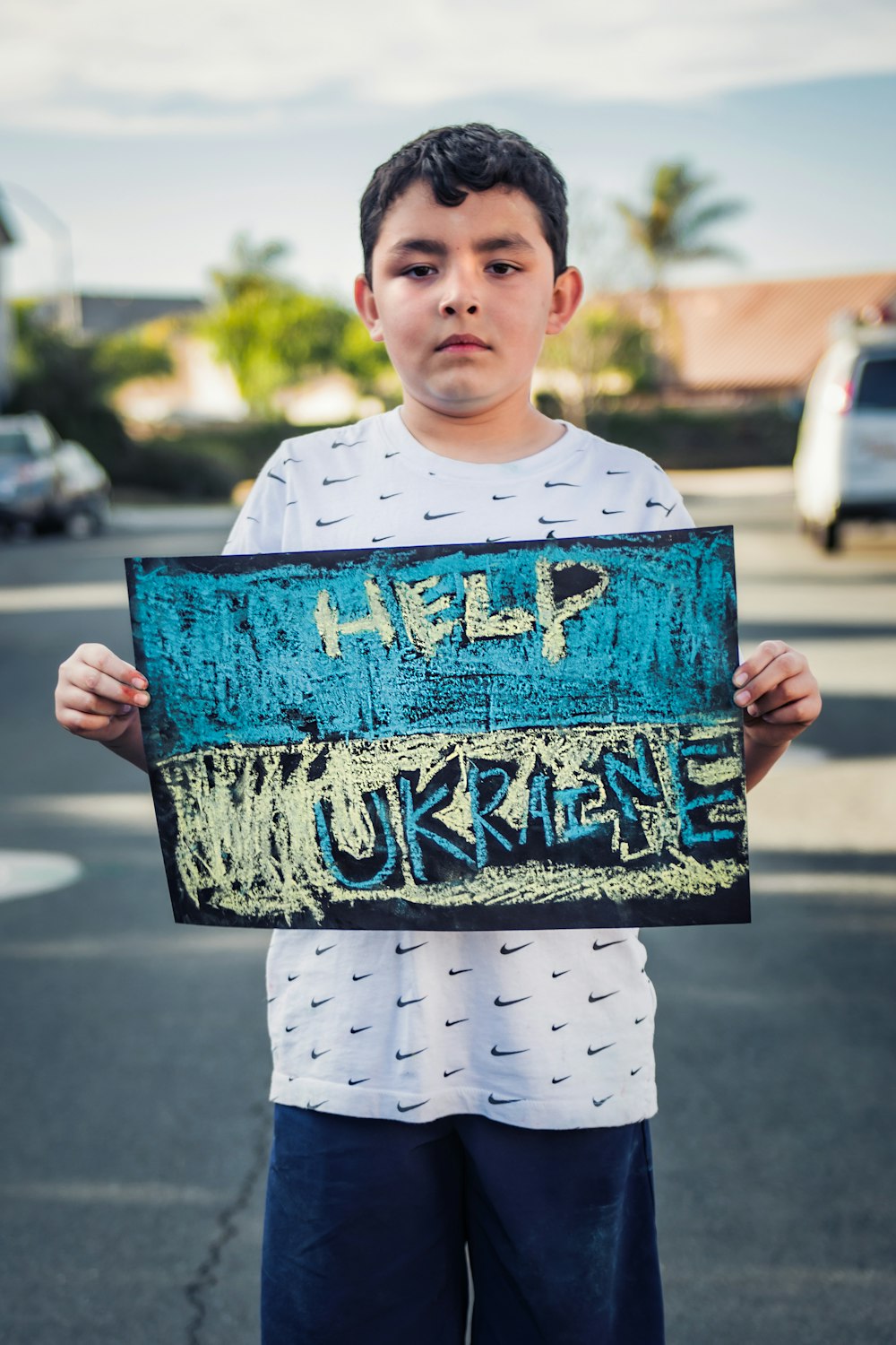 a boy holding a sign that says help hurricane