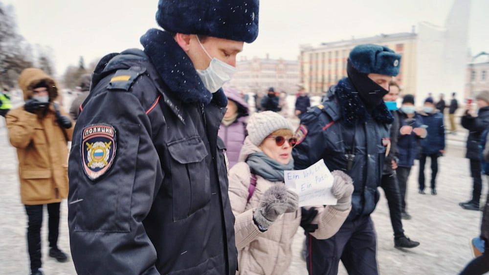 a man wearing a face mask standing next to a woman