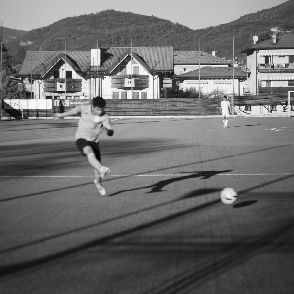 a man kicking a soccer ball across a field