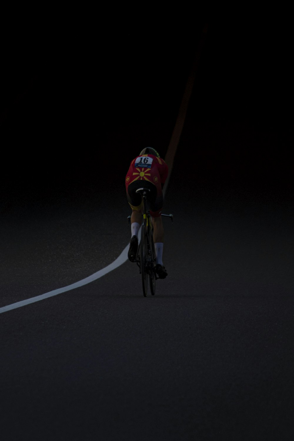 a man riding a bike down a street at night