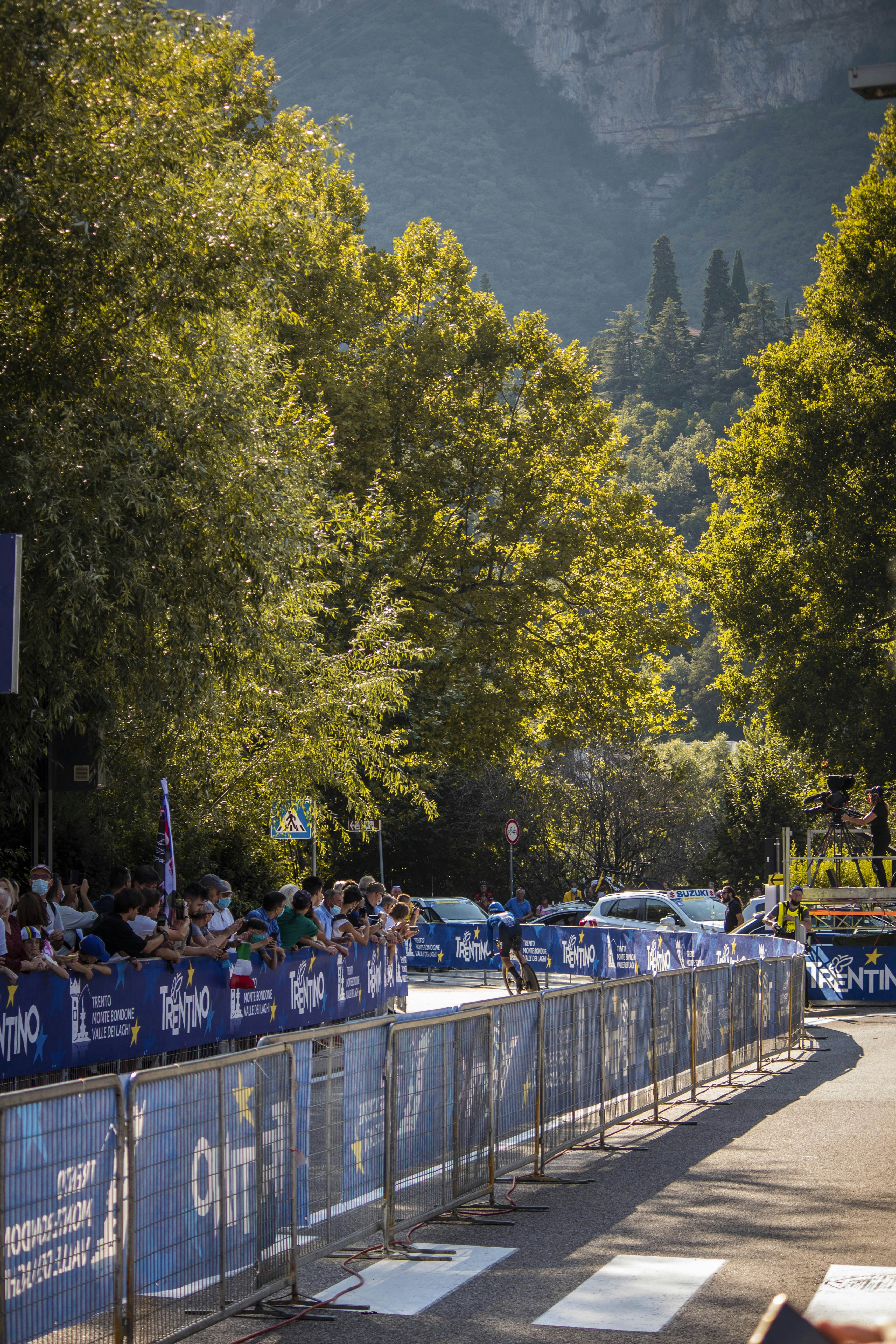 Un hombre montando en bicicleta por una calle junto a una multitud de personas