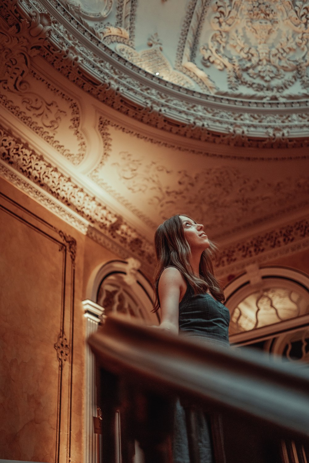 a woman in a black dress standing on a stair case