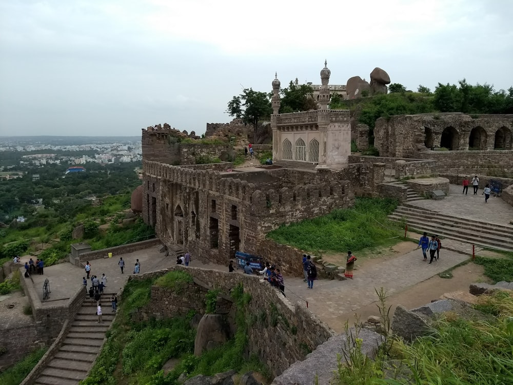 a group of people standing on top of a stone building