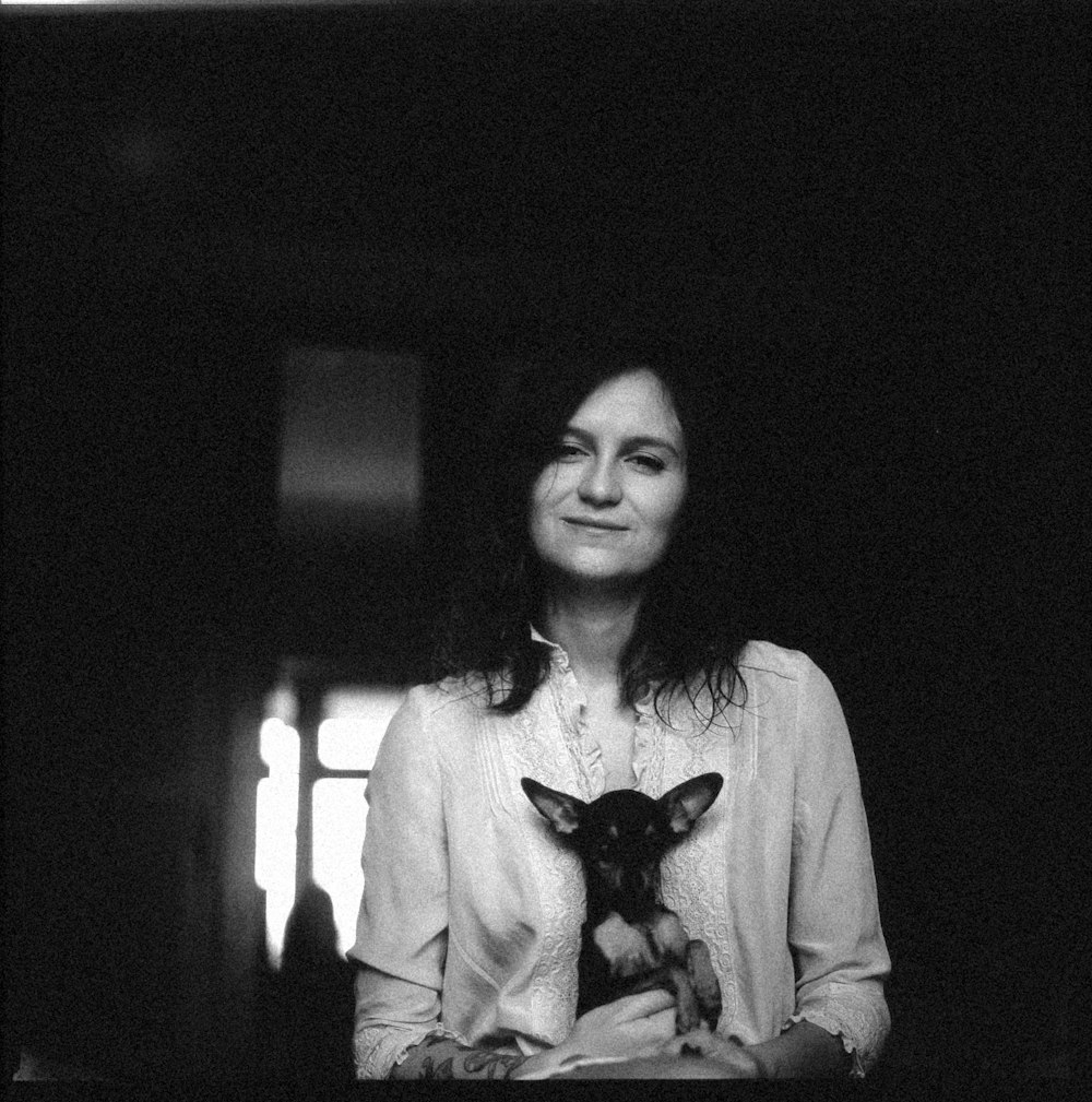 a black and white photo of a woman holding a dog