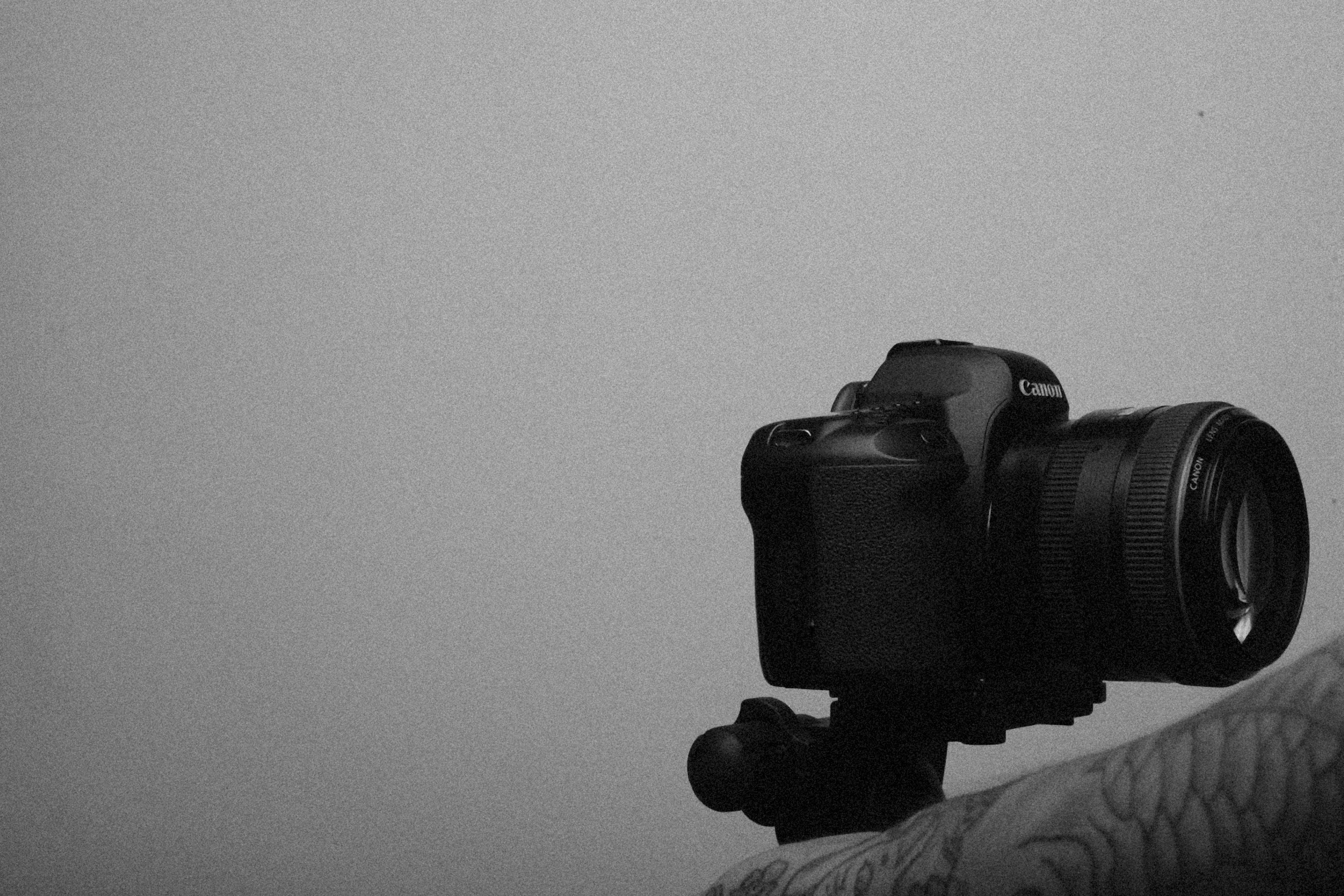 a black and white photo of a person holding a camera