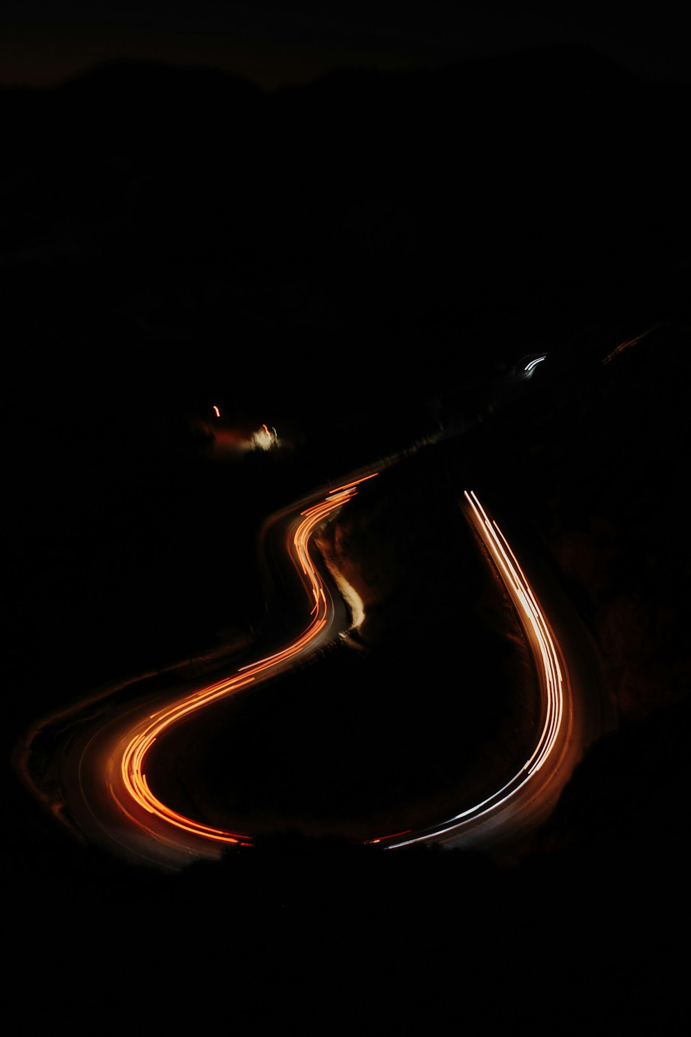 a long exposure photo of a road at night