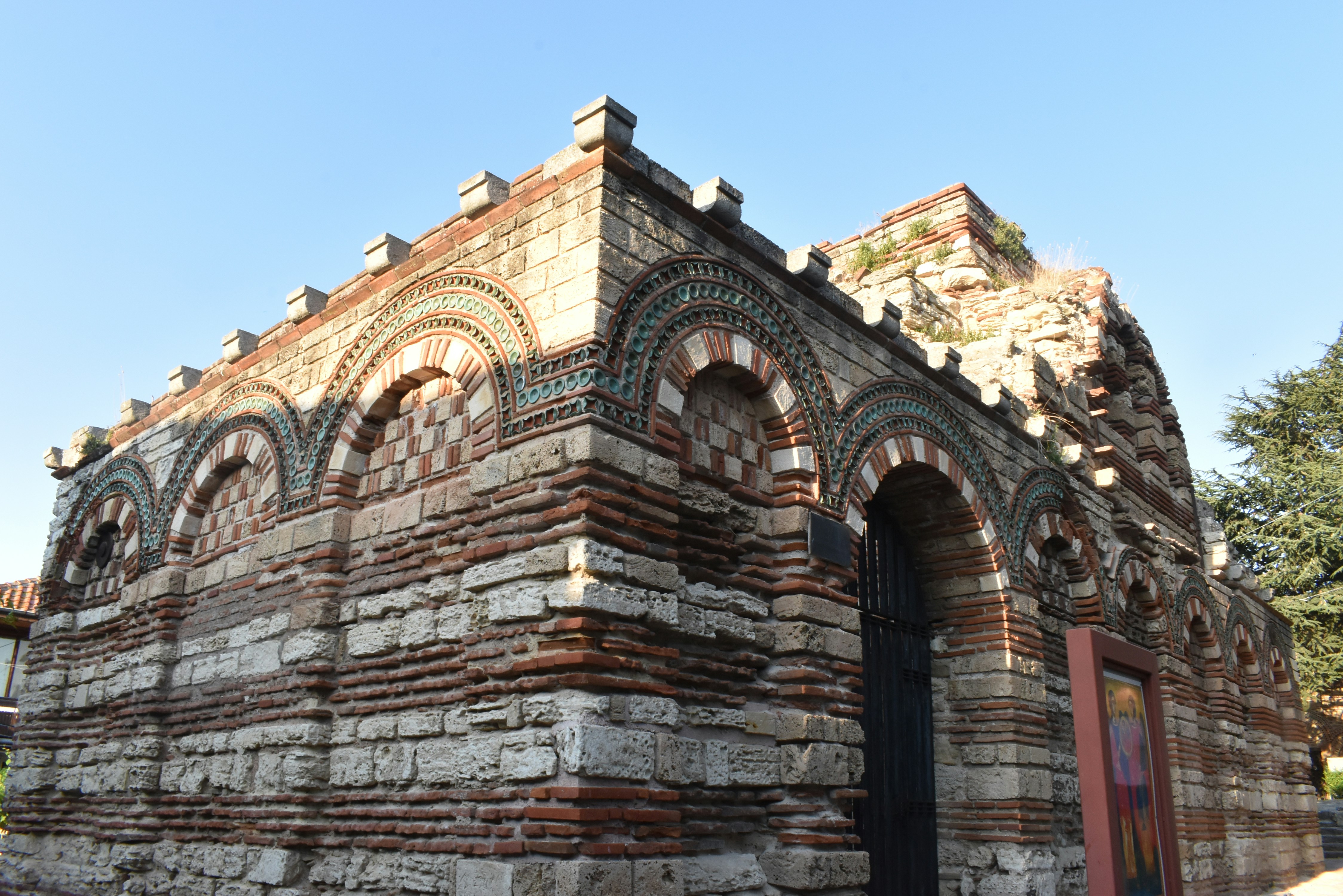 an old brick building with arched windows and a door, 