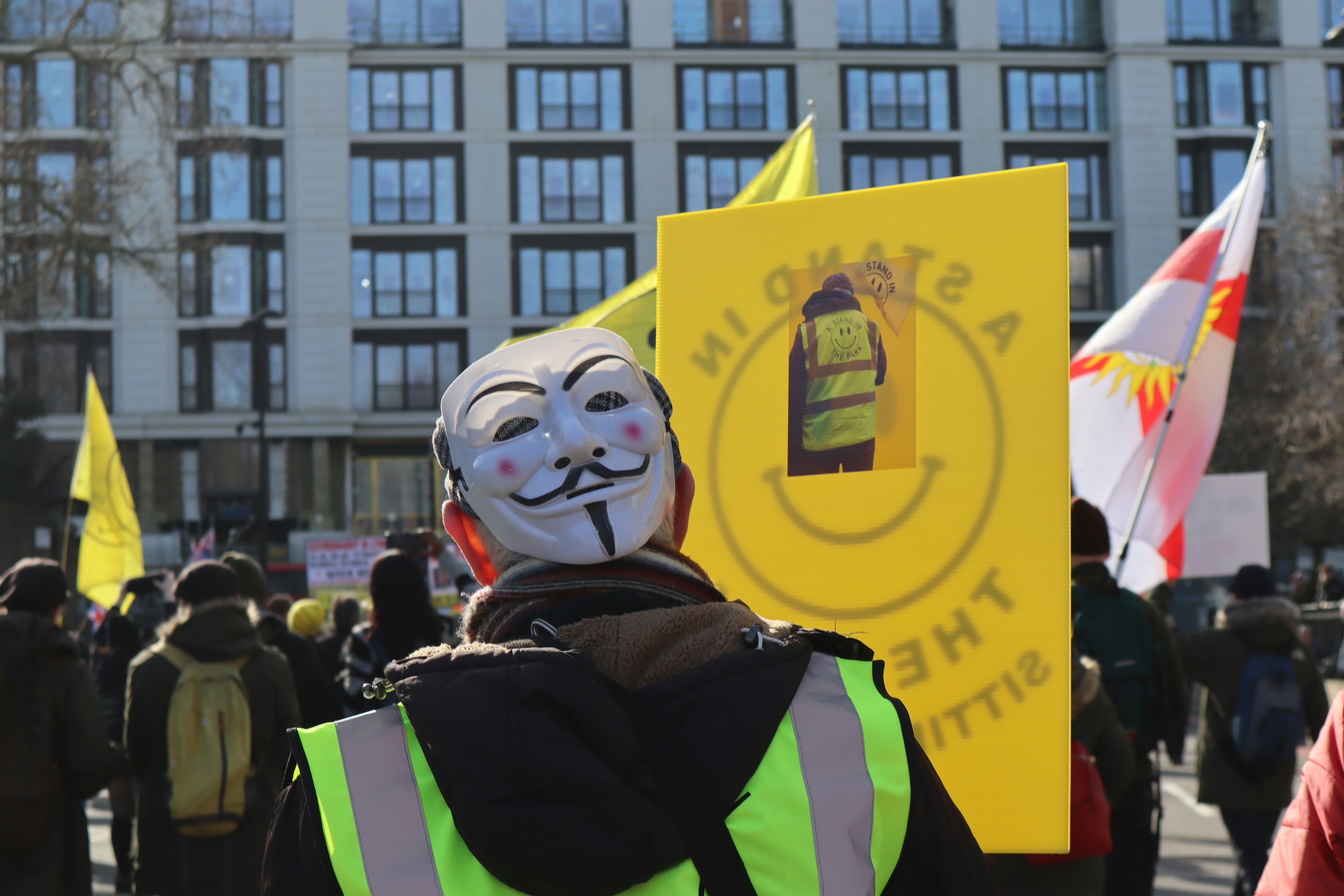 a person wearing a mask and holding a sign