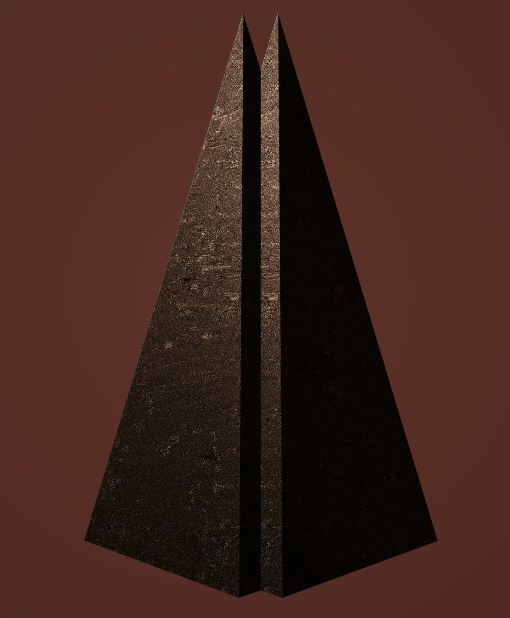 a pair of black triangular shaped objects on a brown background