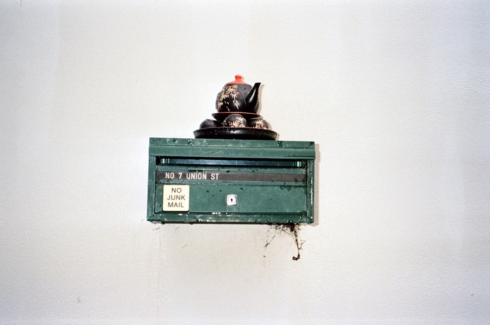 a green box with a teapot on top of it