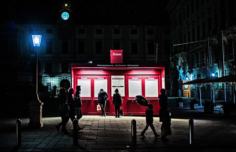 a group of people standing outside of a red building