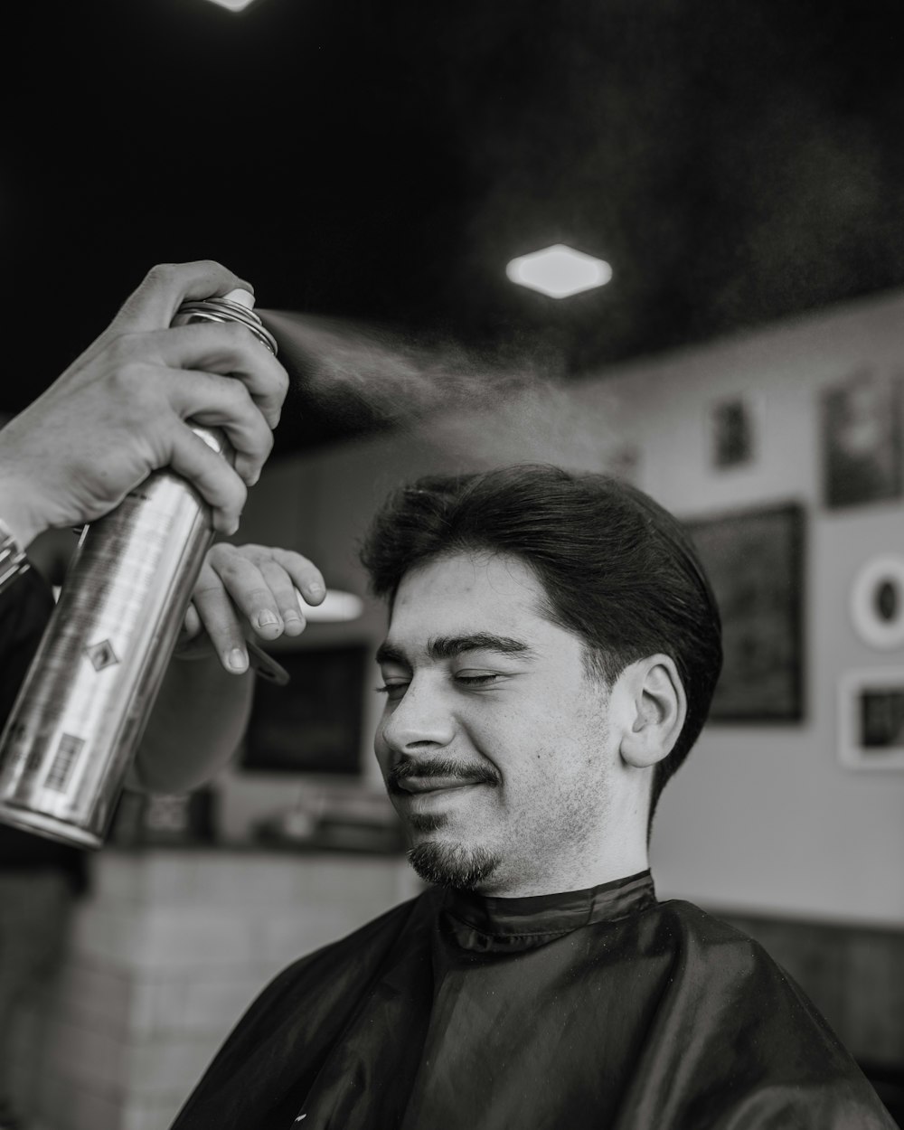 a black and white photo of a man getting a haircut