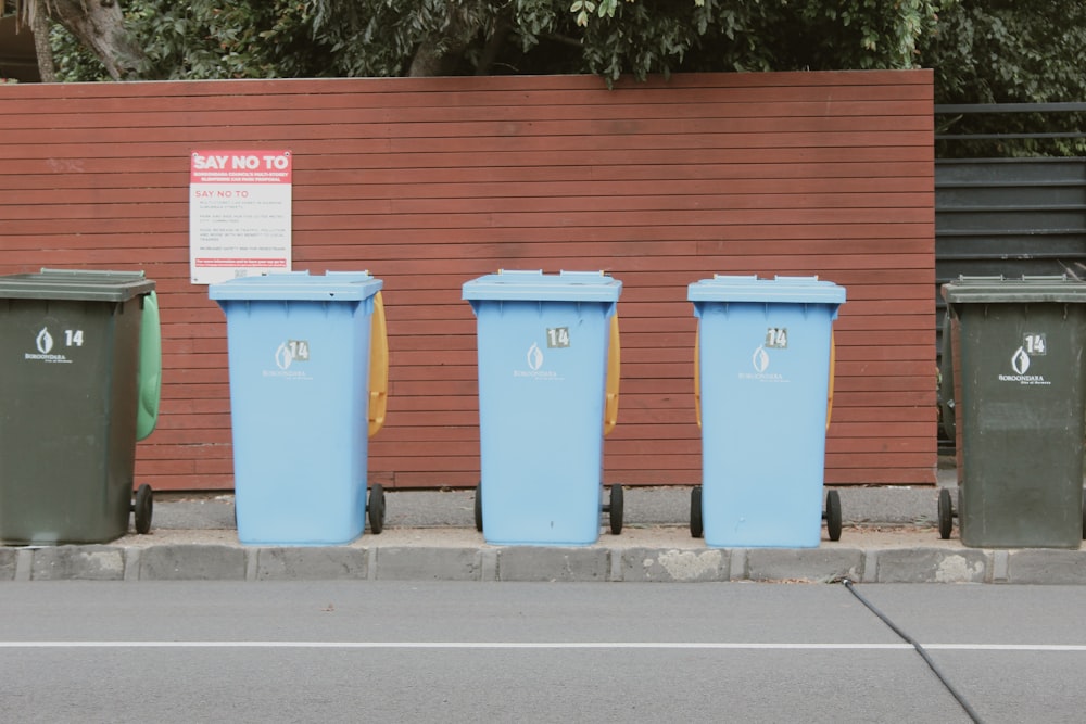 a row of trash cans on the side of a road