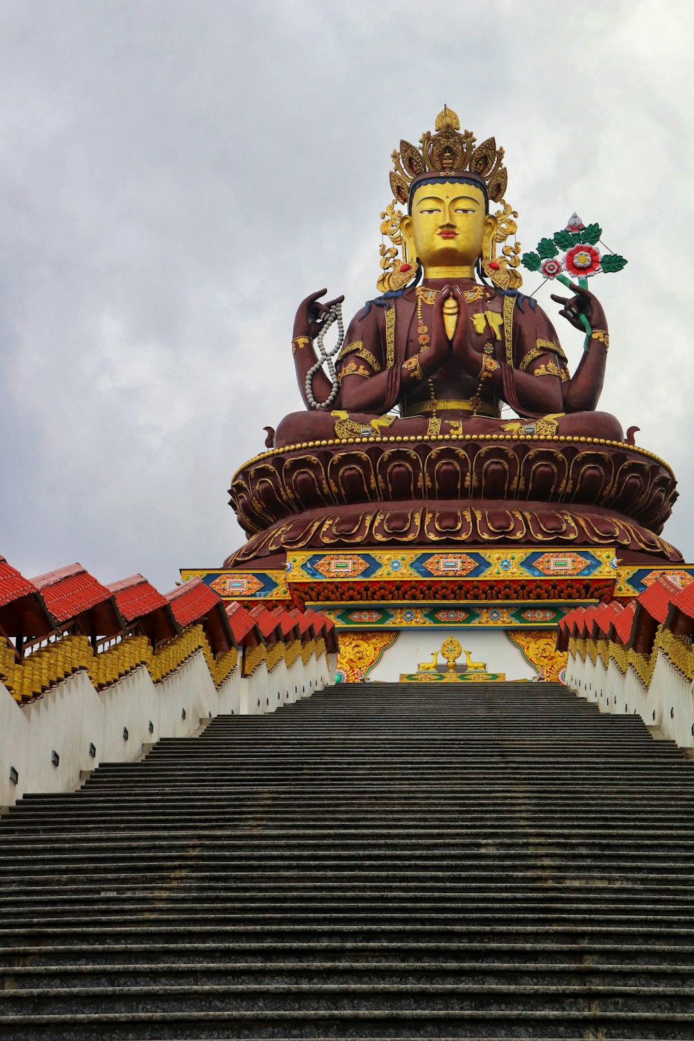 a statue of a buddha sitting on top of a set of stairs