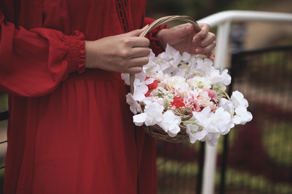 a woman in a red dress holding a basket of flowers