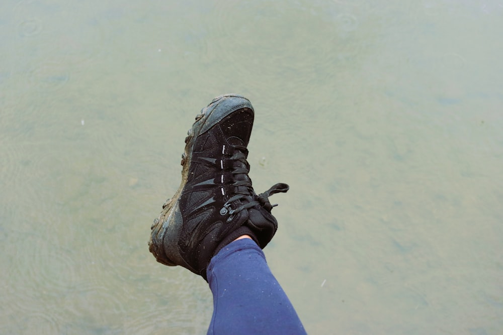 a person standing in the water with their feet in the water