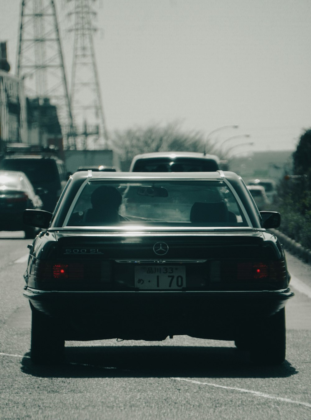 a black car driving down a street next to tall buildings