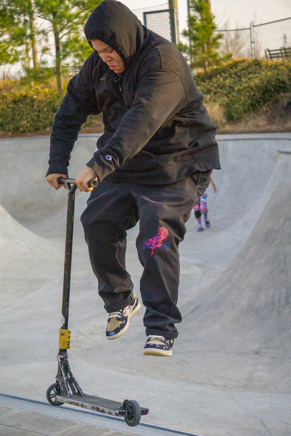 a man riding a scooter at a skate park