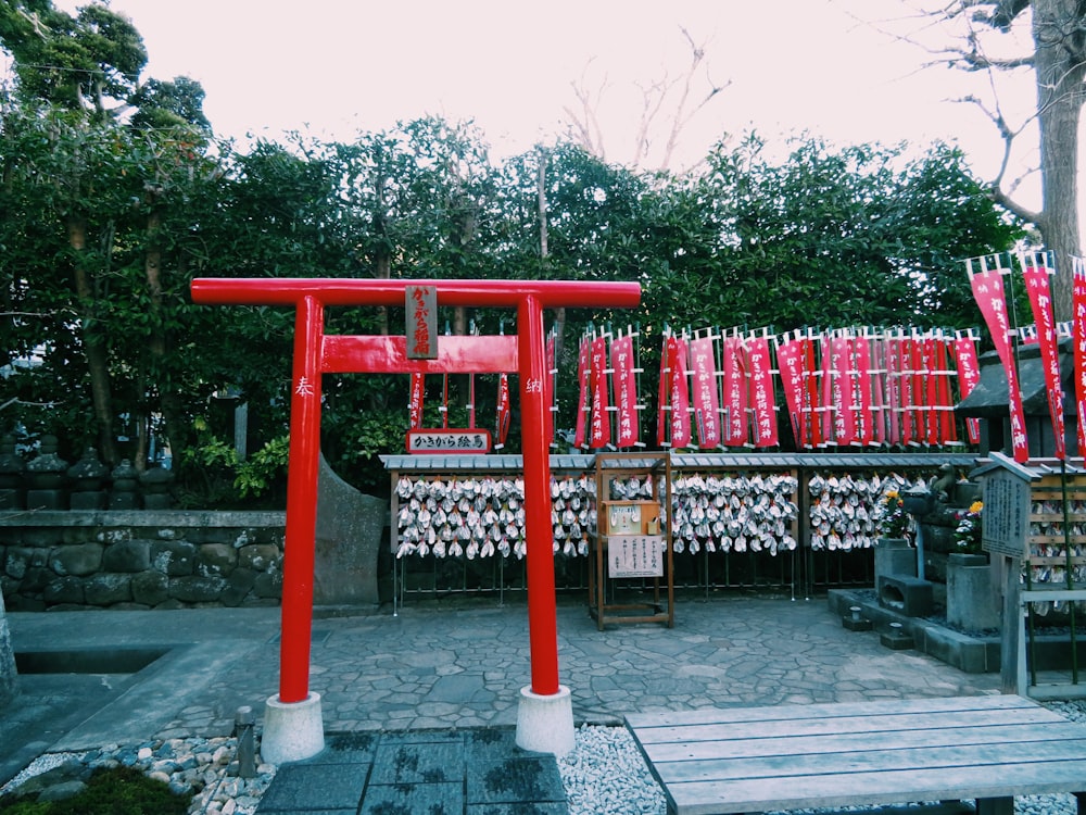 a wooden bench sitting in front of a red structure