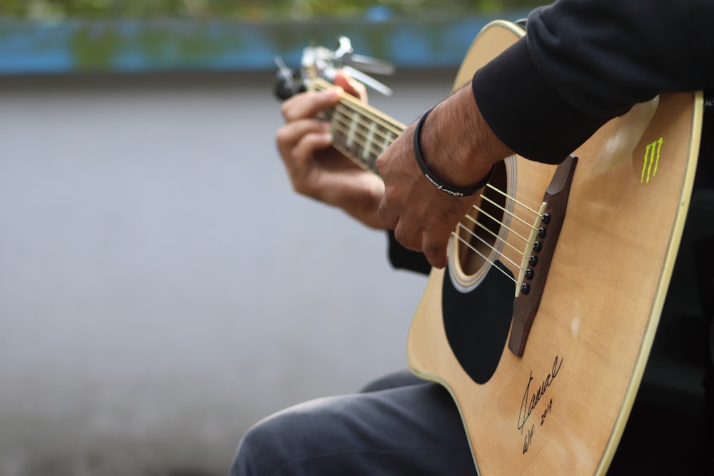 Un homme joue de la guitare à l’extérieur
