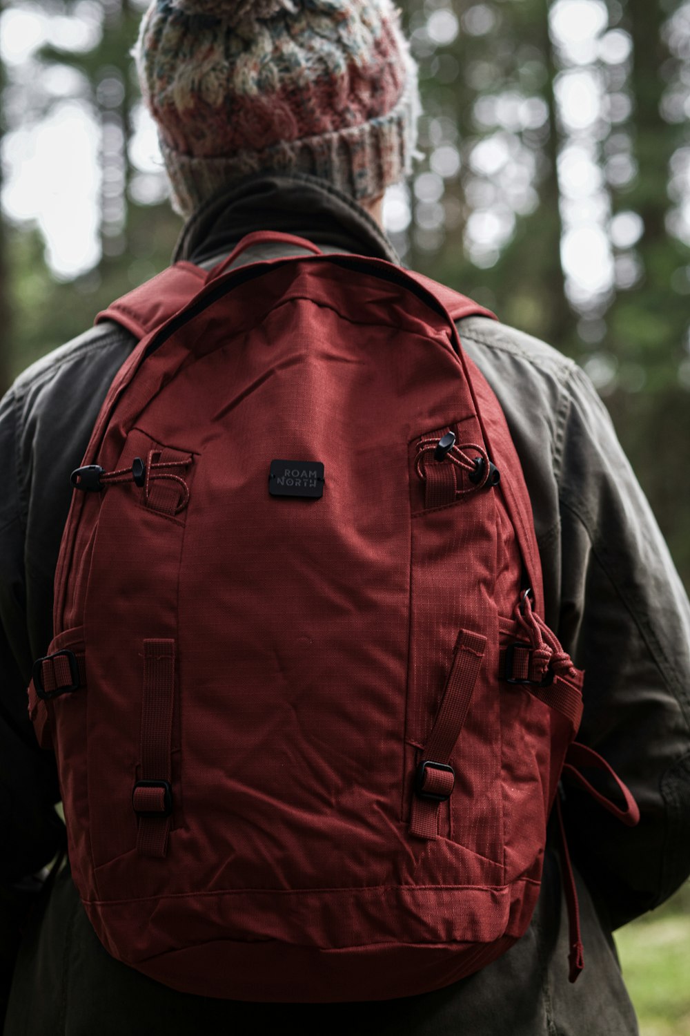 a person wearing a red backpack in the woods