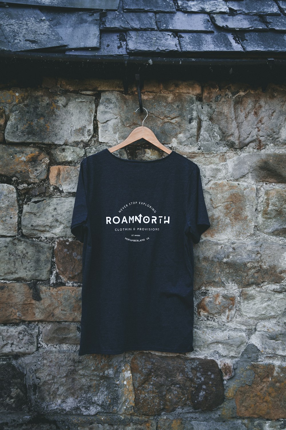 a t - shirt hanging on a stone wall
