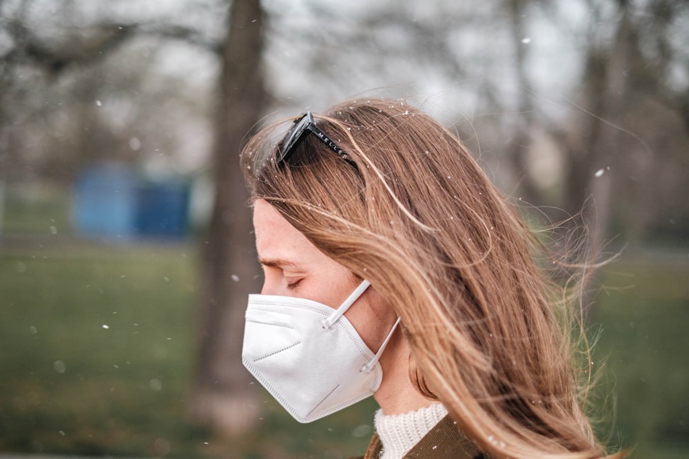 a woman wearing a face mask in a park