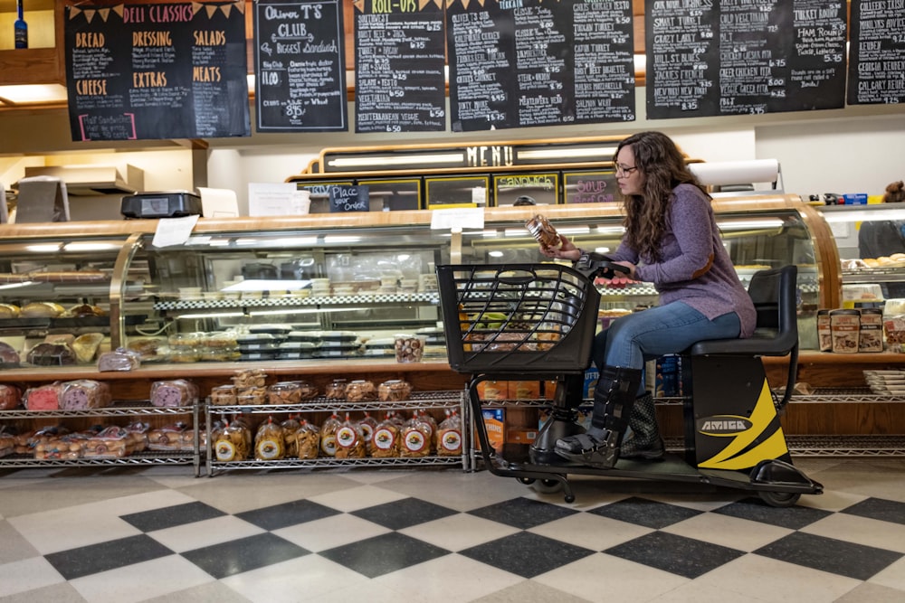 a woman sitting on a scooter in front of a bakery
