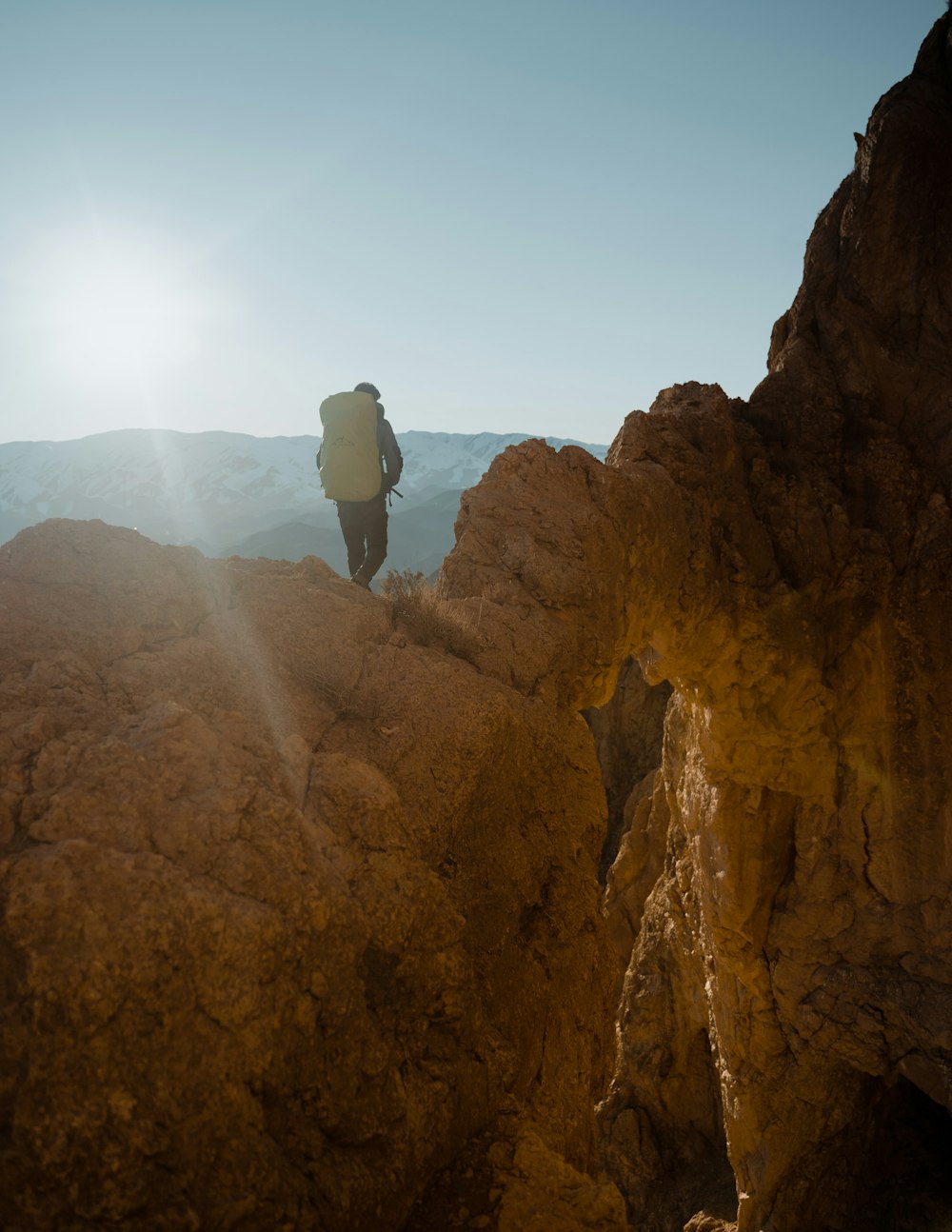 a person with a backpack walking up a mountain