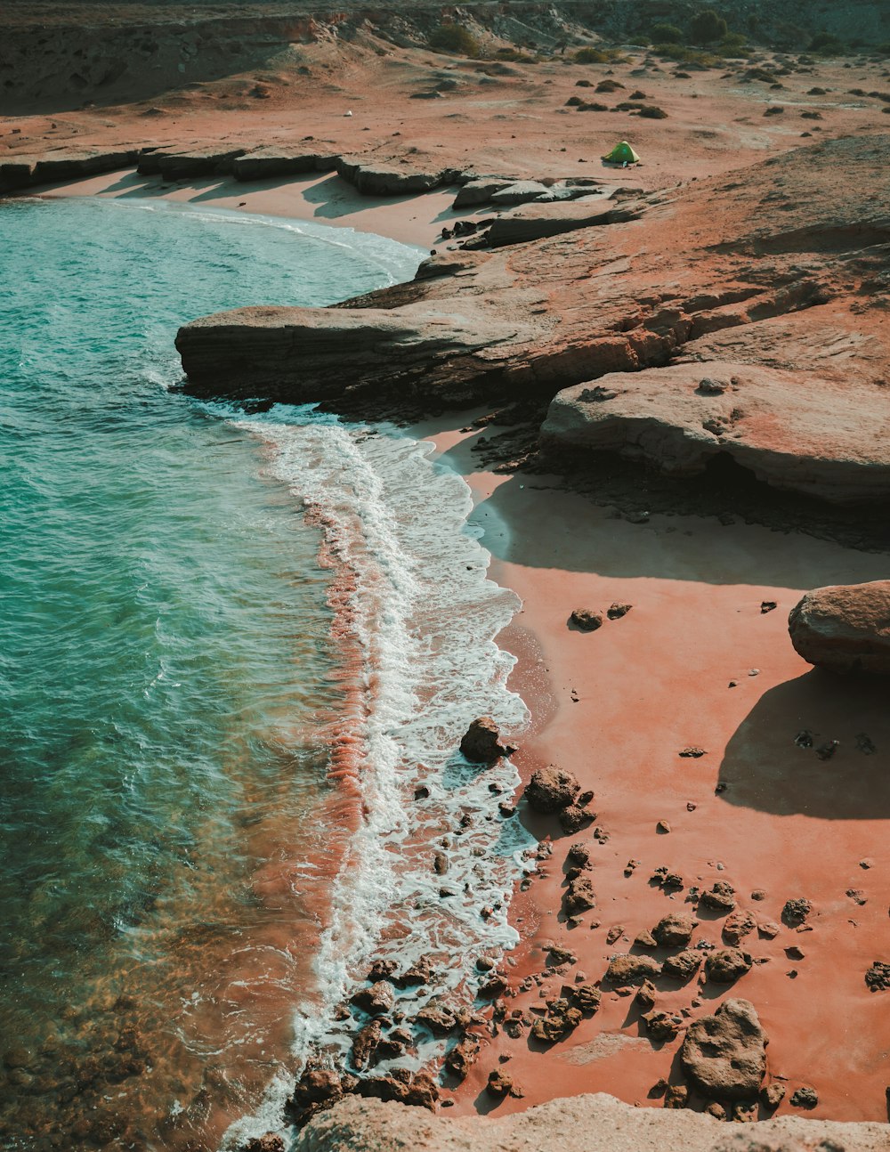 a sandy beach with a body of water next to it