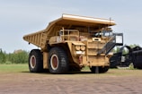 a large dump truck parked on top of a dirt field