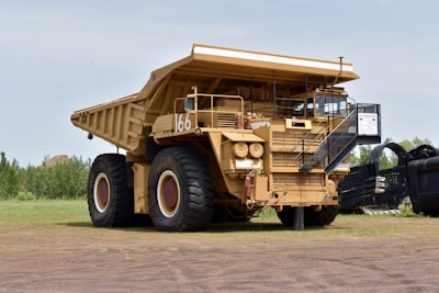 a large dump truck parked on top of a dirt field
