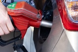 a person pumping gas into a car at a gas station