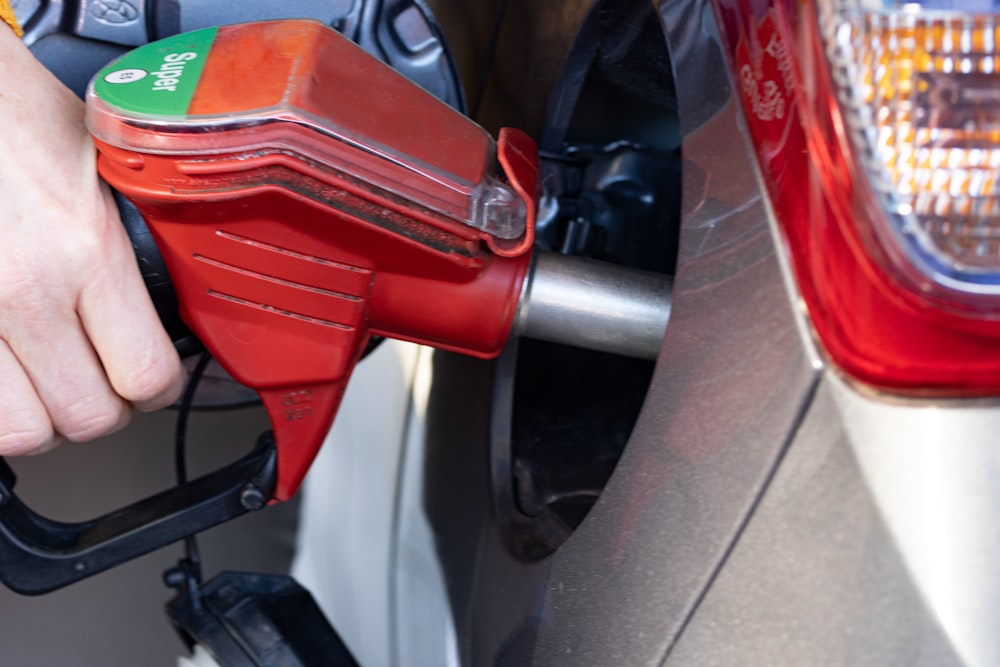 a person pumping gas into a car at a gas station