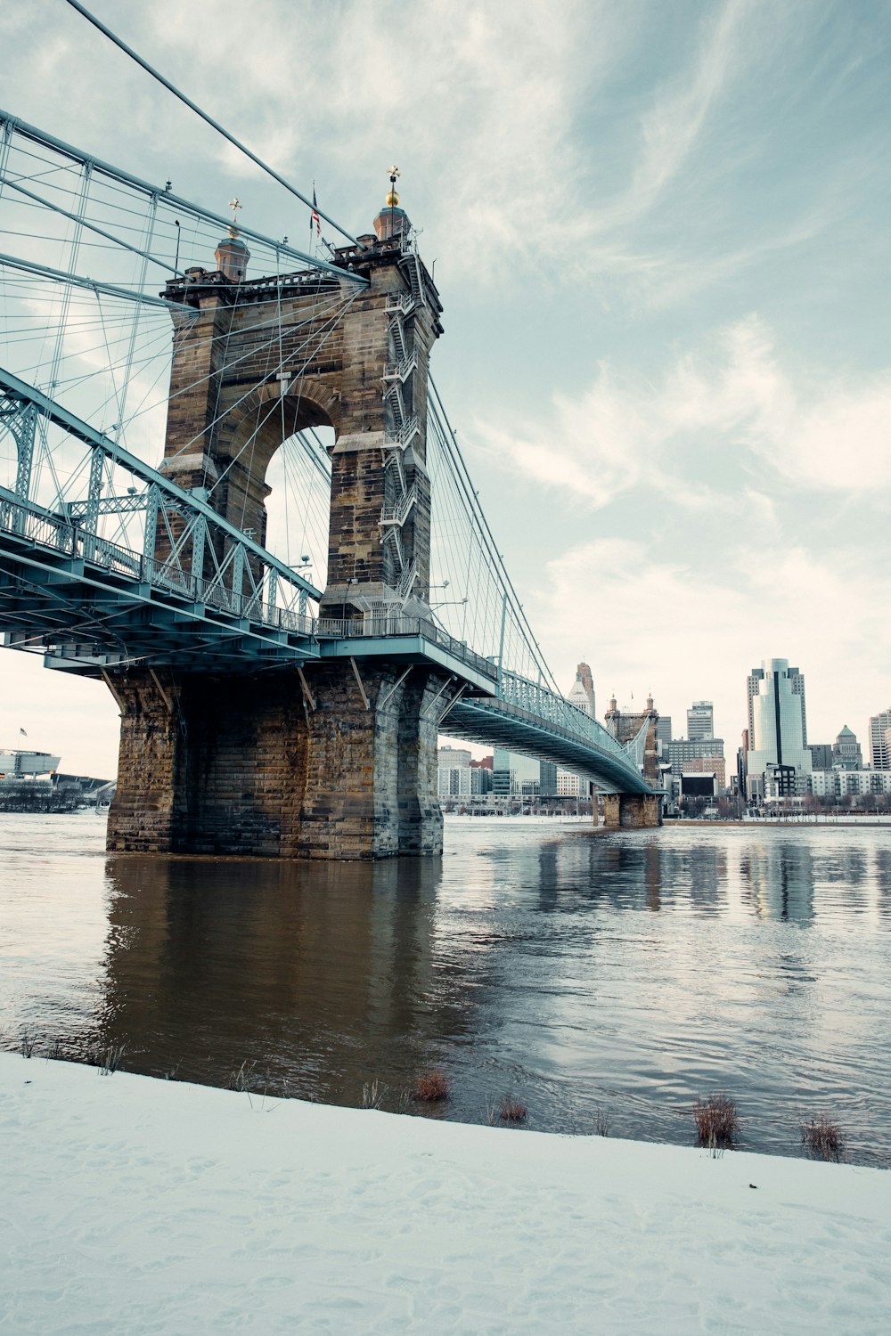 a bridge over a body of water with a city in the background