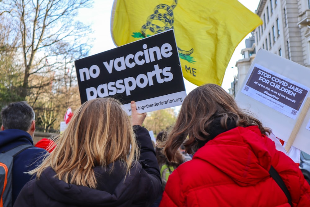 a group of people holding up signs in front of a building