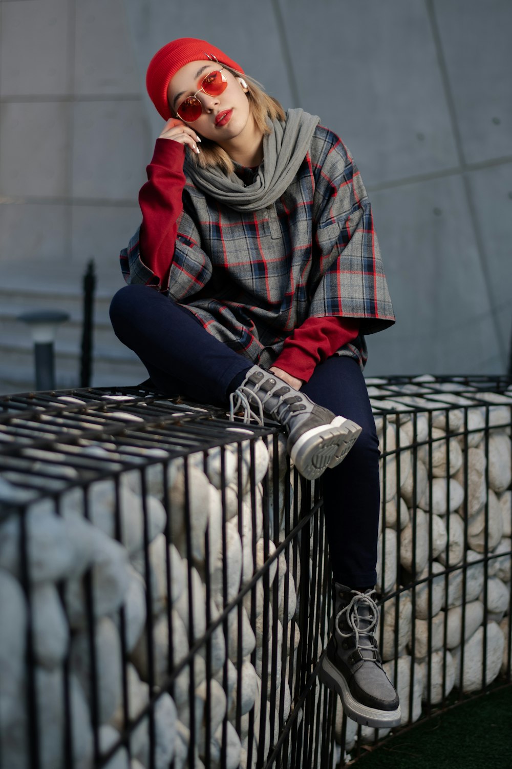 a woman sitting on top of a cage next to a pile of balls