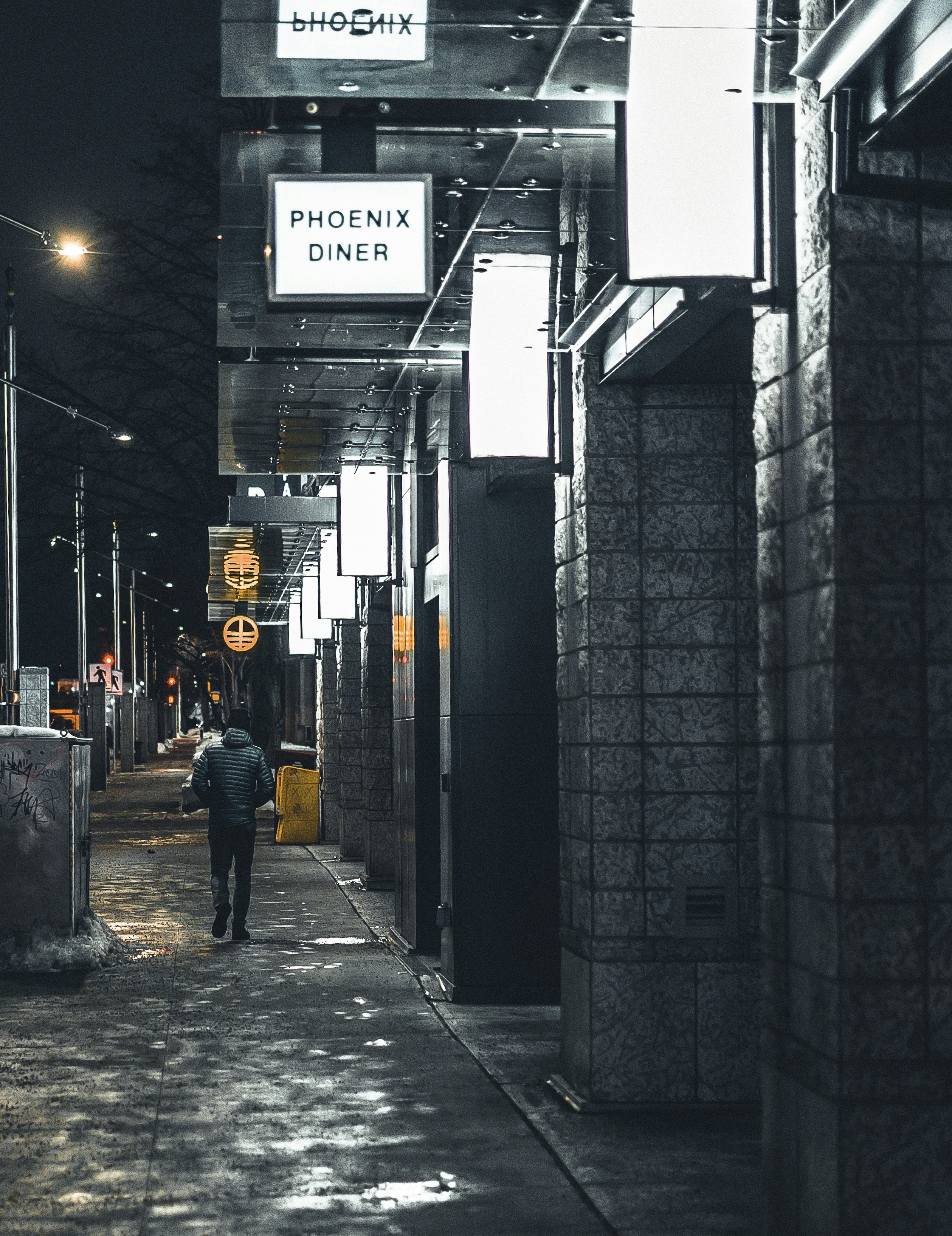 a person walking down a street at night