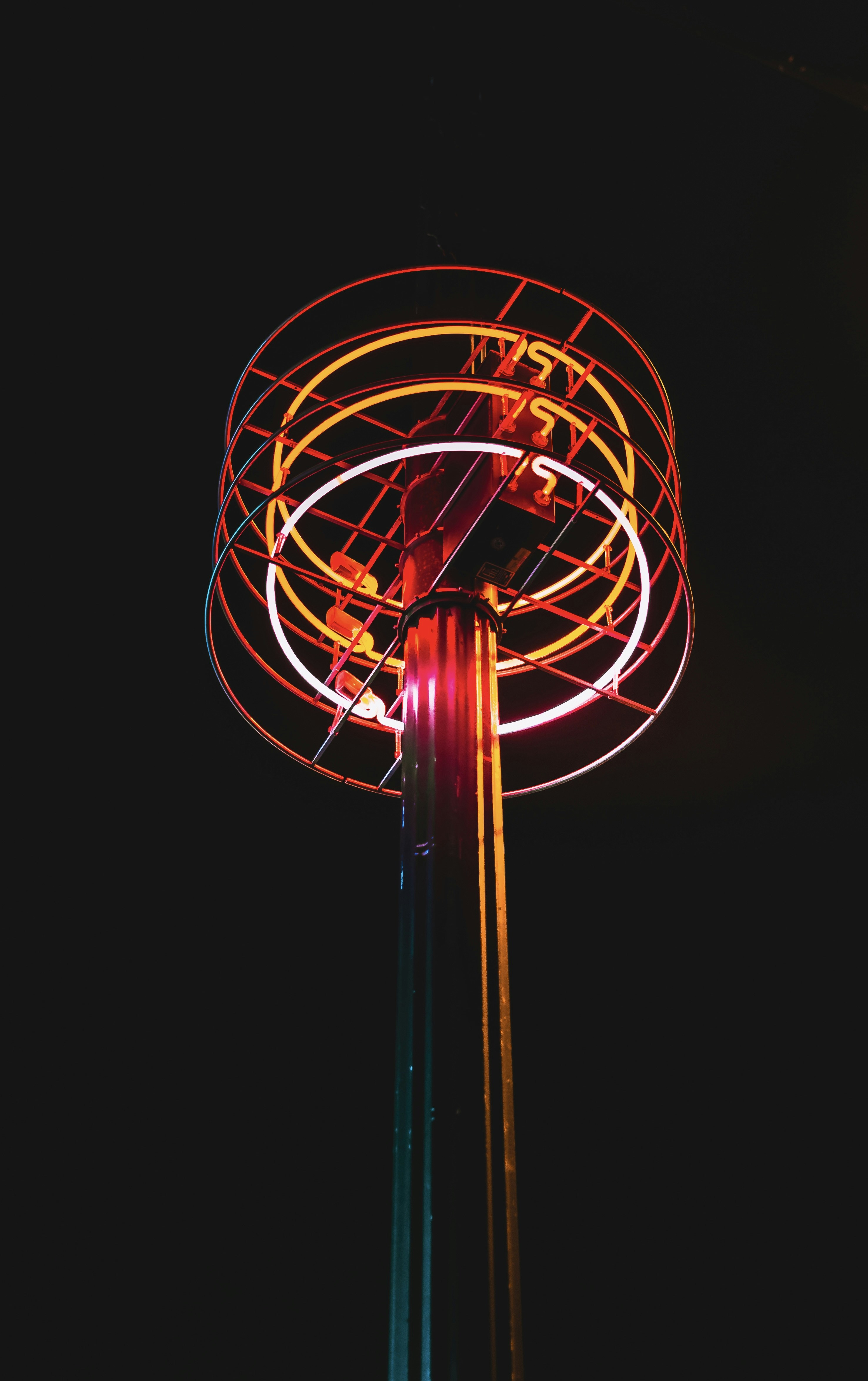 a tall pole with a neon light on top of it