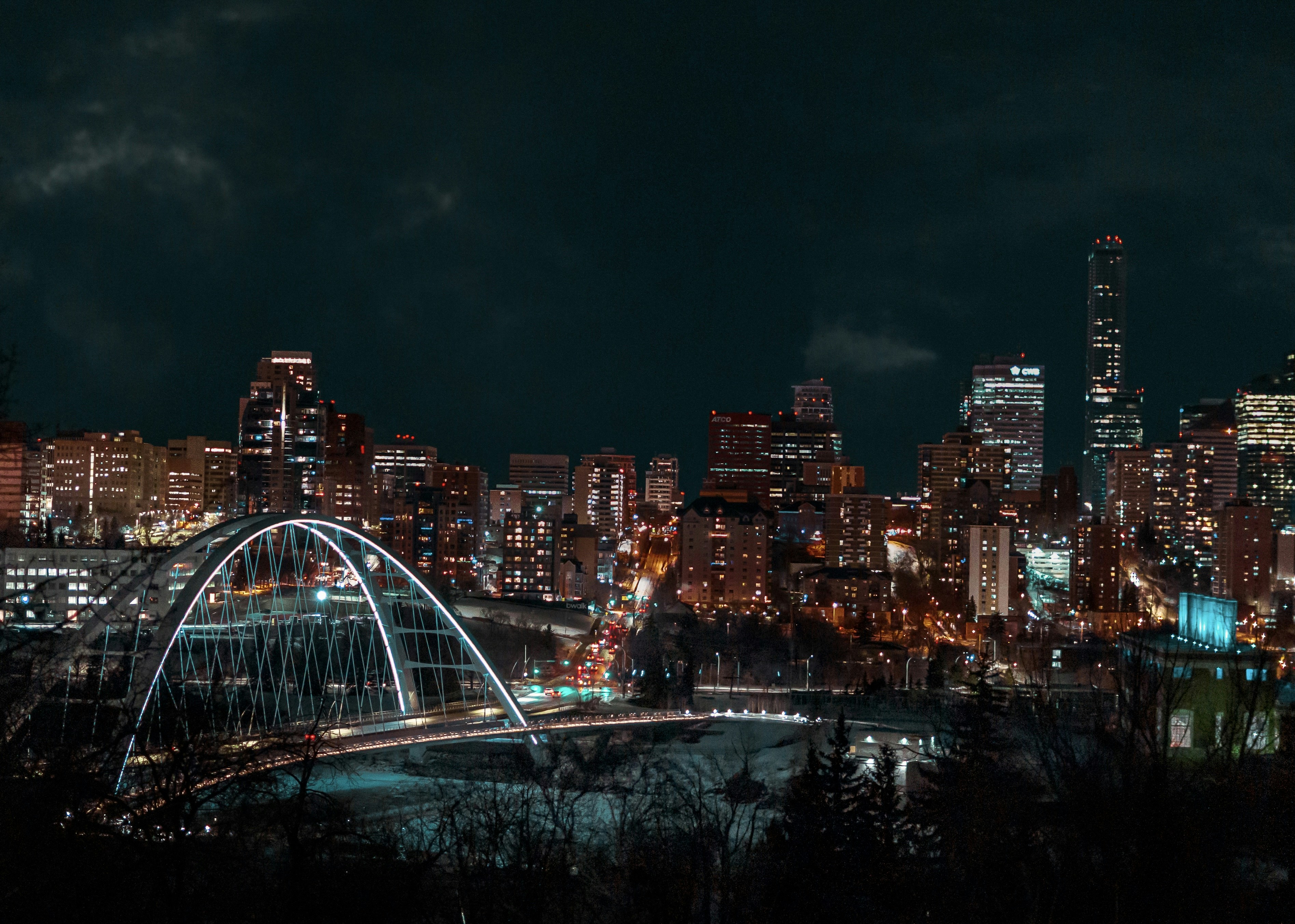 a night view of a city with a bridge in the foreground