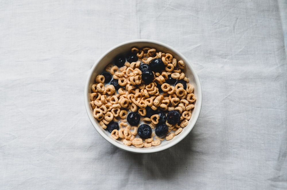 a white bowl filled with cereal and blueberries