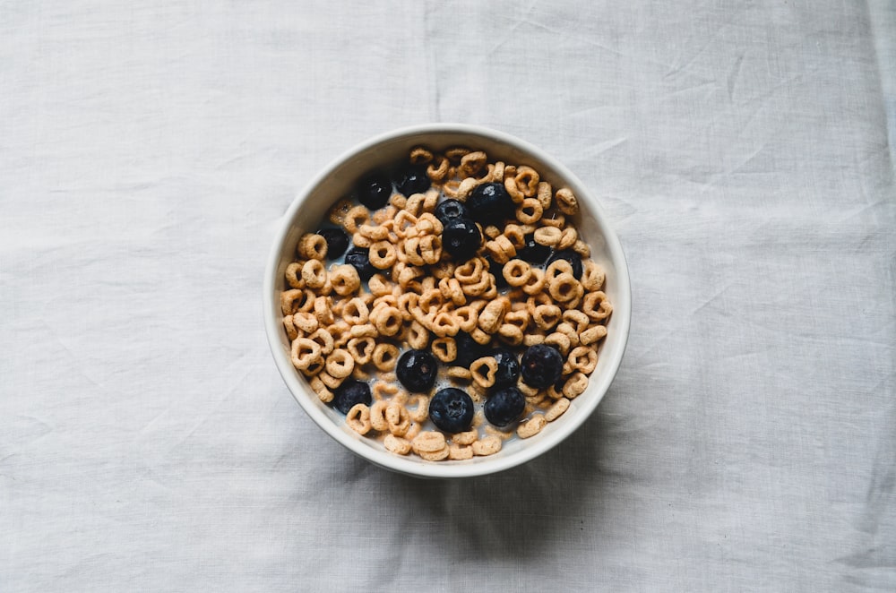 eine weiße Schüssel gefüllt mit Müsli und Blaubeeren