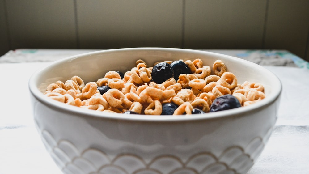 un tazón blanco lleno de cereales y arándanos