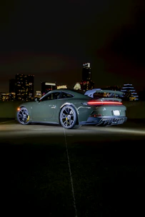 Sporty hybrid coupe gleaming under bright city lights at night.