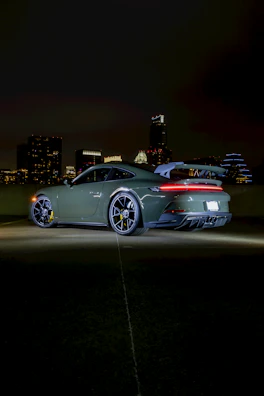 Side profile of a polished sports car reflecting city lights in Overland Park.