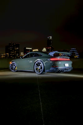 Sporty hybrid coupe gleaming under bright city lights at night.