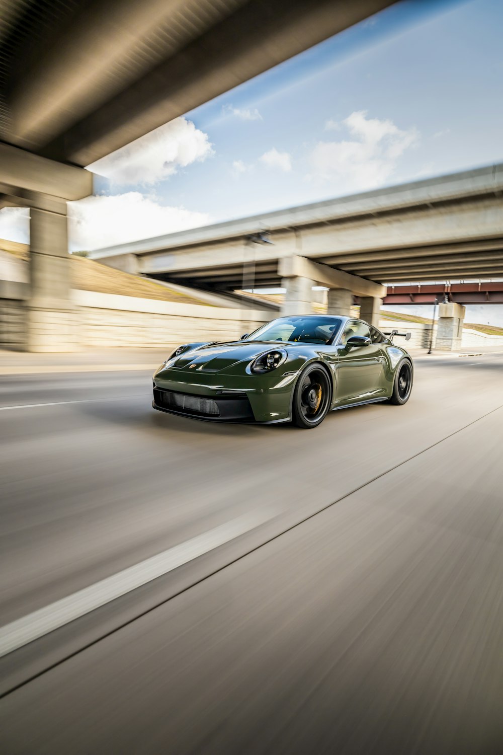 a green sports car driving down a highway